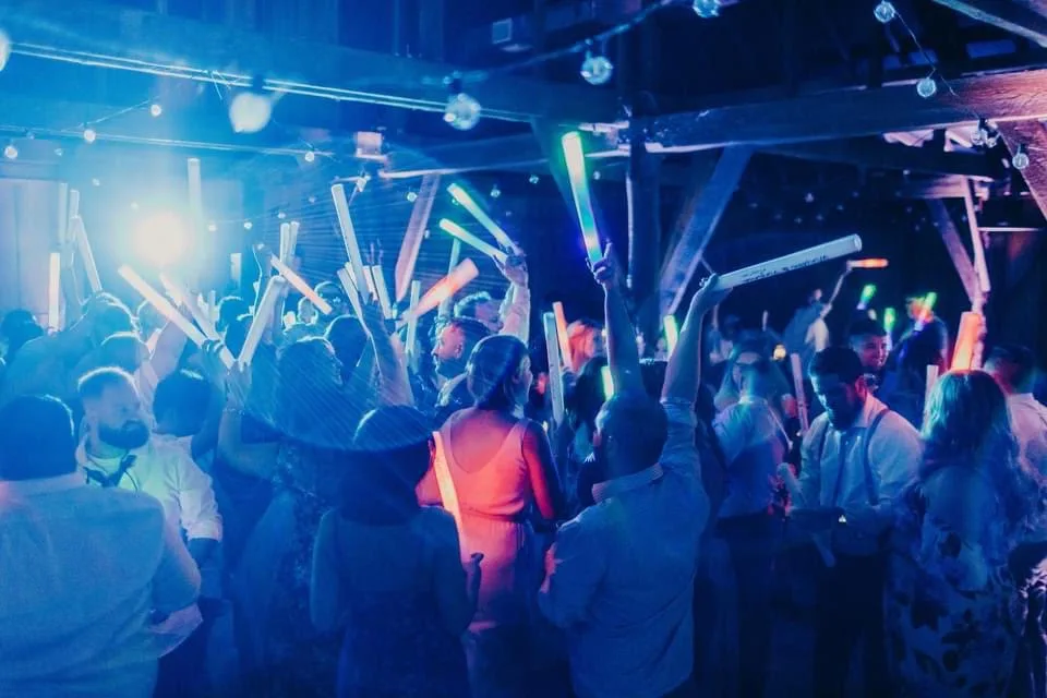 wedding glow stick dance floor party tampa bay - Services Excited wedding guests wave colorful LED foam glow sticks on a packed dance floor at a Tampa Bay wedding reception enhanced by Events Done Right Tampa Bay DJ services